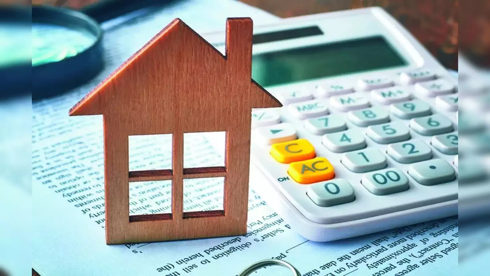 A wooden house on a calculation sheet and a calculator